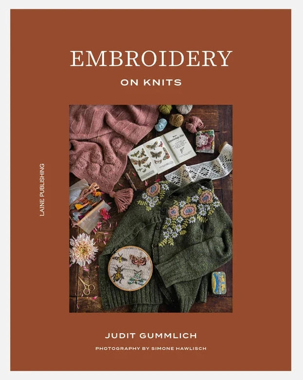 A book cover titled 'EMBROIDERY ON KNITS' by Judit Gummlich, featuring a warm rust-brown background and a central square photo of knitted textiles, embroidery thread, beads, and sewing supplies arranged on a dark surface.
